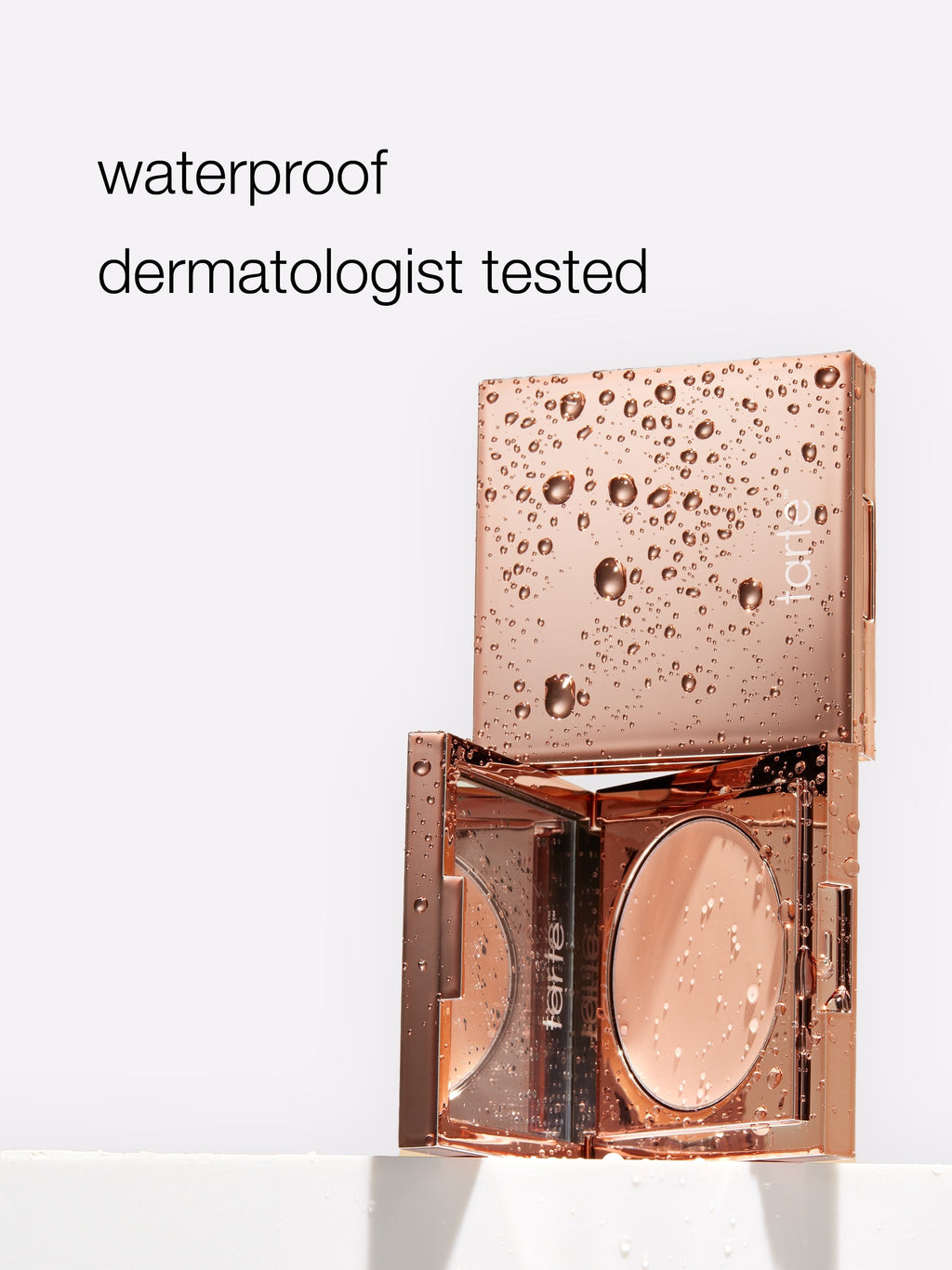 Rose gold compact with water droplets and 'waterproof dermatologist tested' text on a white background